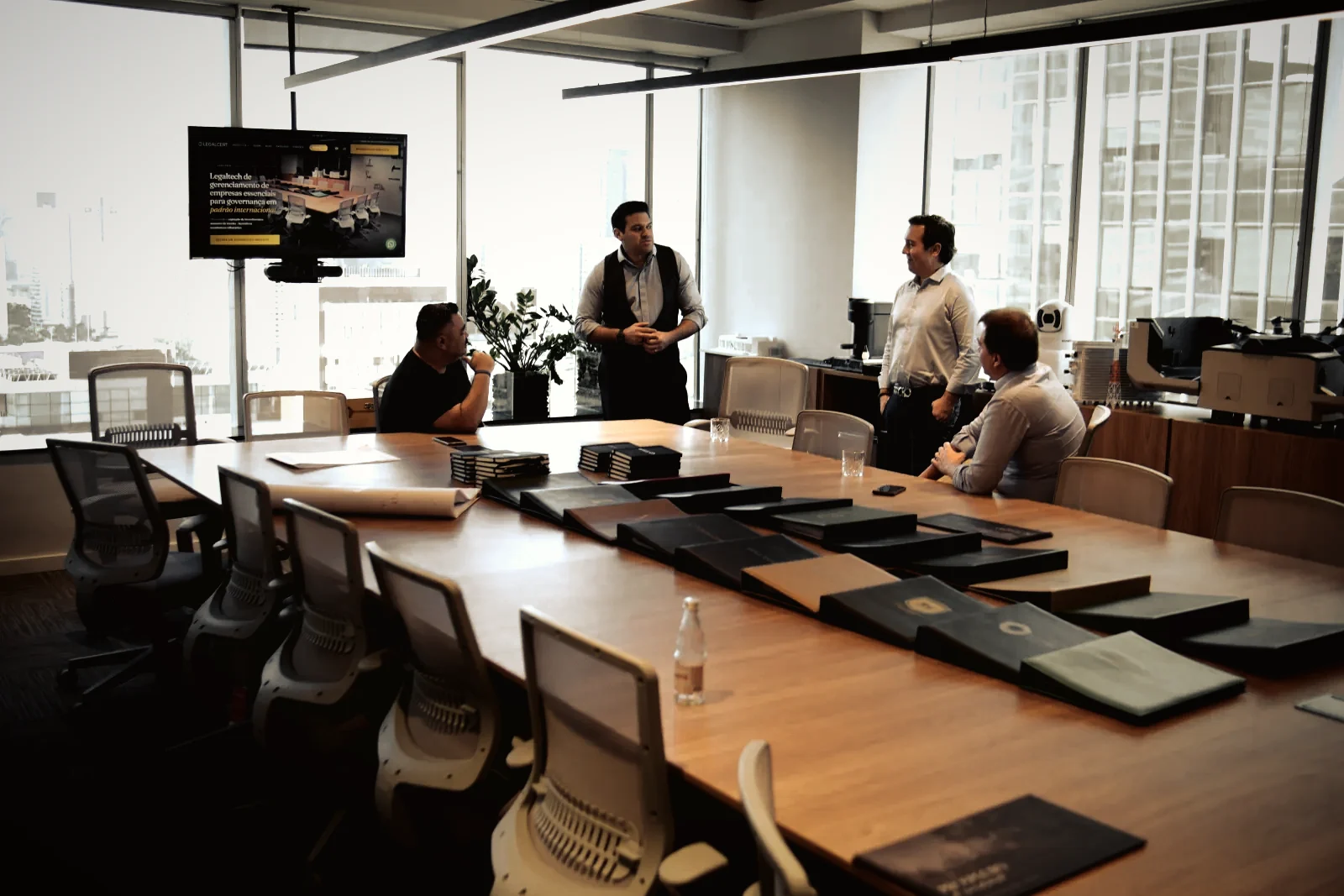 Reunião na sala principal, com o site da Legalcert na TV
