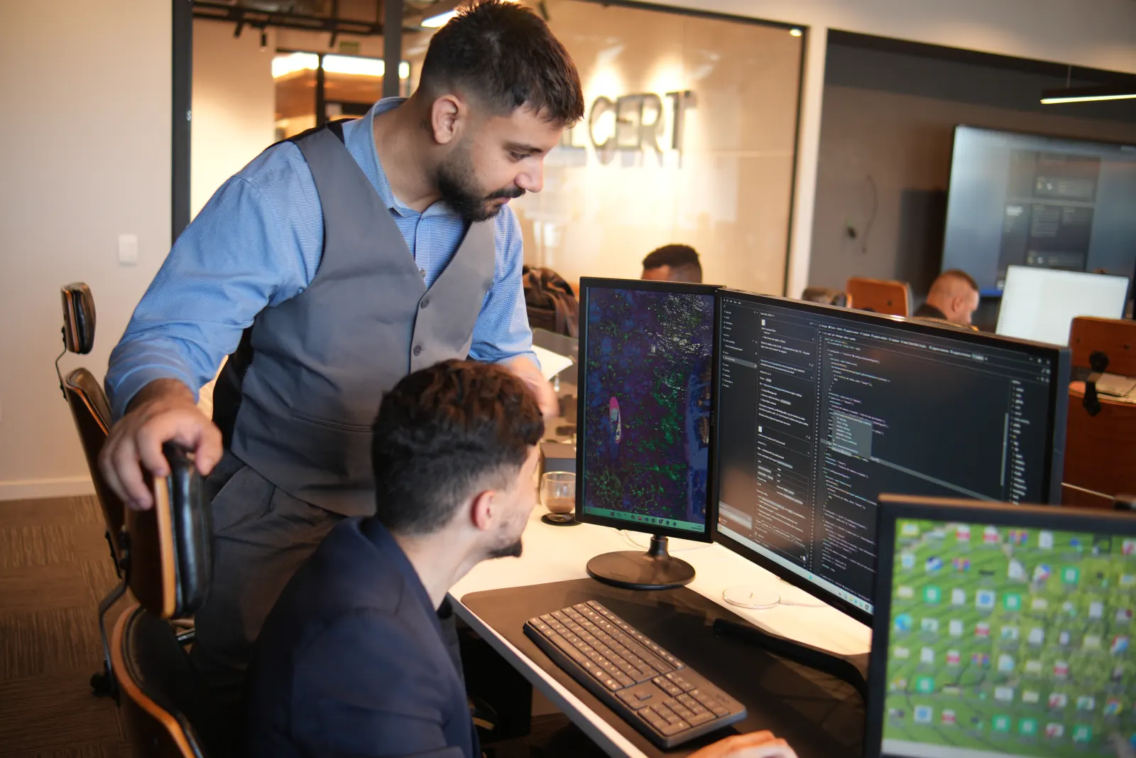 Dupla do time de tecnologia revisando código no escritório