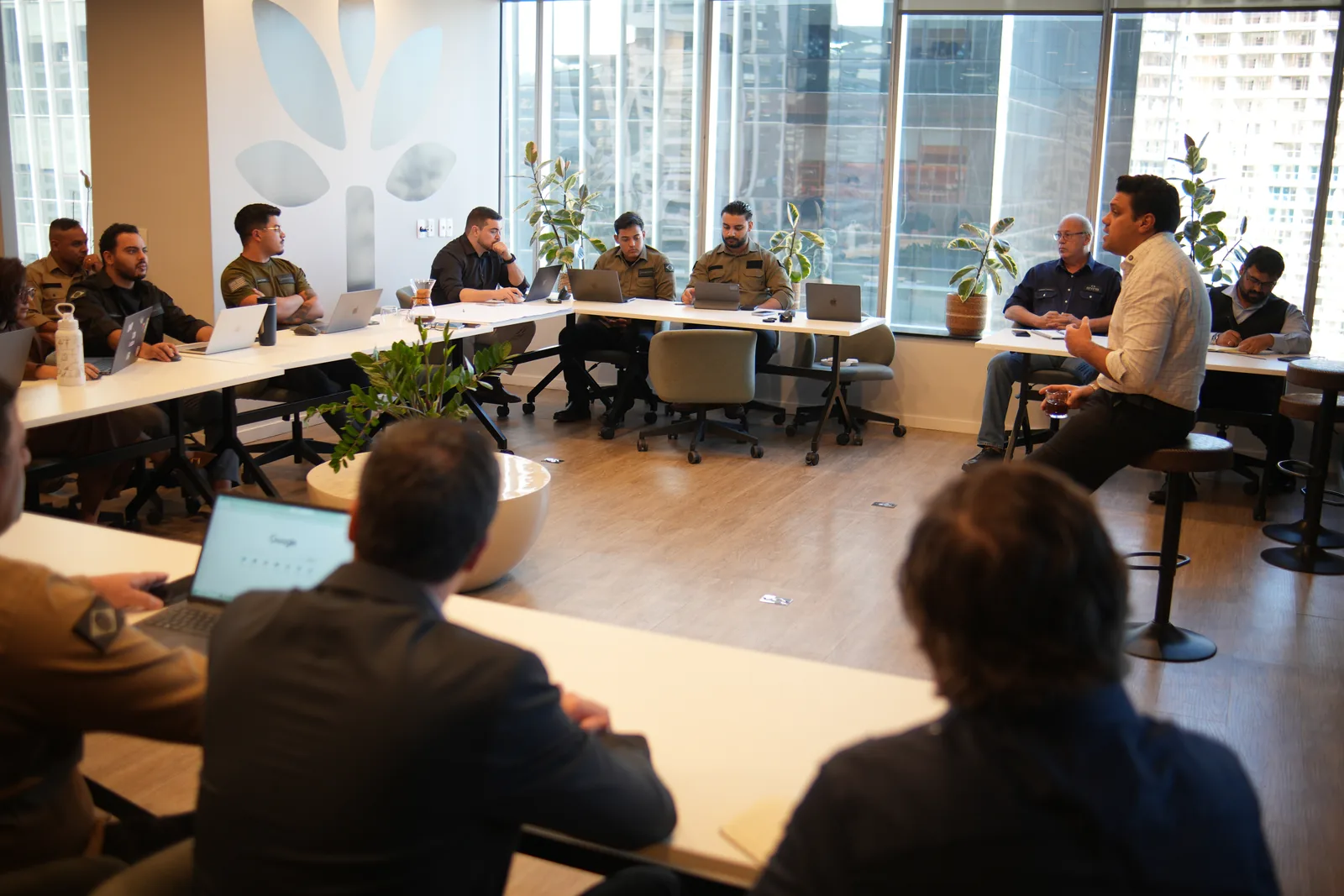 Turma de treinamento em sala, com o time reunido em mesa em U