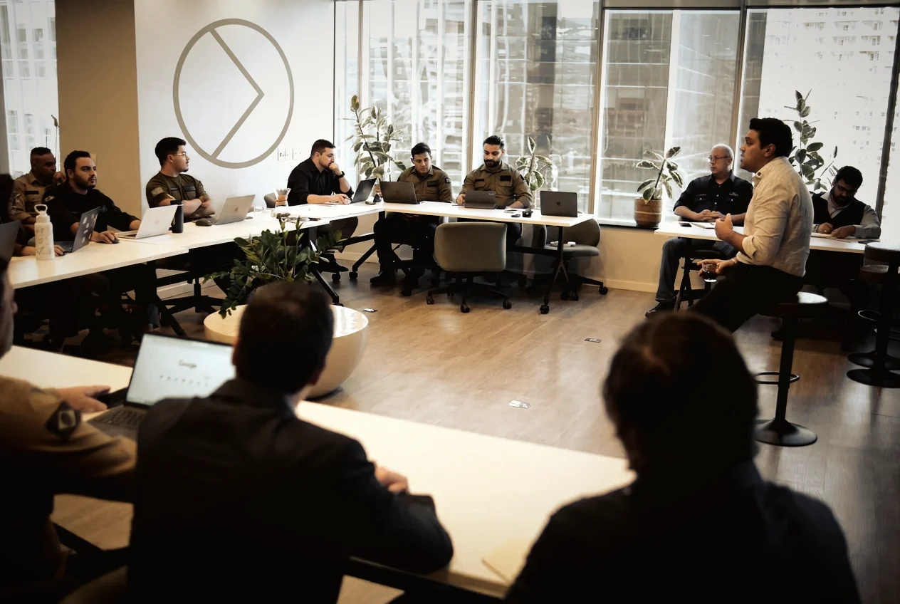 Turma de treinamento em sala, com o time reunido em mesa em U